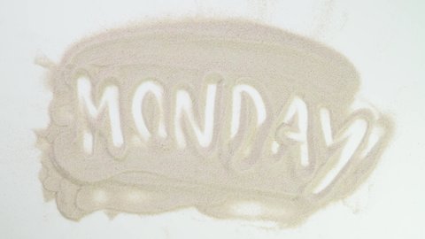 Monday. beginning of the week. Top view draw on the sand. Caucasian hands write text in beige sand. Vacation and travel. Beach on vacation. Sand painting. Creativity from natural materials.