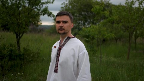 Serious and motivated caucasian man in traditional Ukrainian embroidered vyshyvanka showing fist and strength. Concept of not giving up with willpower and continuing to fight the enemy at all costs
