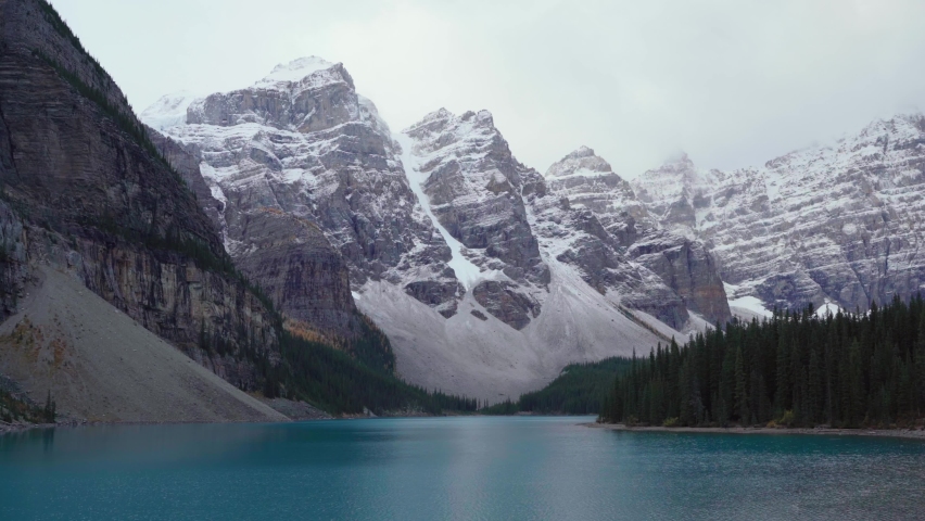 View of Moraine lake. Scenic view of the Valley Ten Peaks in Banff National Park, Alberta, Canada. Footage of Iconic, Famous Place. Mountains with snow and pine autumn forest. 