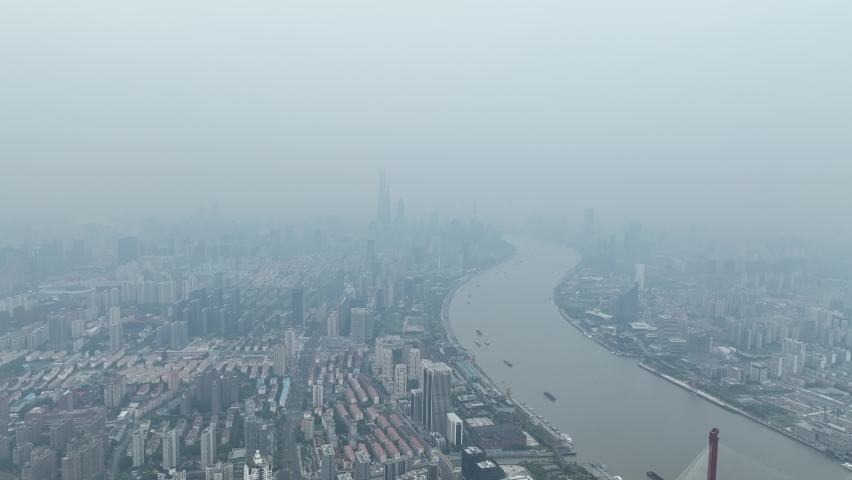 Drone aerial view of Foggy weather and cityscape in cloudy day. Drone flying over the city of downtown Shanghai China in the mist in cloudy day. Business, travel, economy concept b-roll footage.