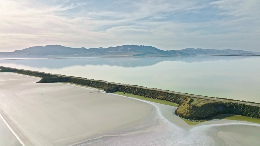 Aerial - Amazing Road and Mountains Reflection at the Great Salt Lake in Utah, Truck Right Shot.