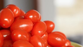 Close-up view 4k stock video footage of tasty fresh juicy small oblong organic tomato cherry vegetables isolated. Food abstract video background