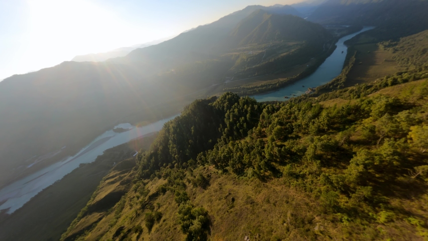 Picturesque sunlight aerial view amazing natural mountain valley dense green trees river landscape at early morning. FPV sports drone shot dive cliff stone texture forest plant grass at hilly terrain