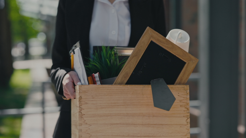 Close up of caucasian young woman leaving business center with box of personal items after being fired. Career crisis and job loss concept. Royalty-Free Stock Footage #1091279453