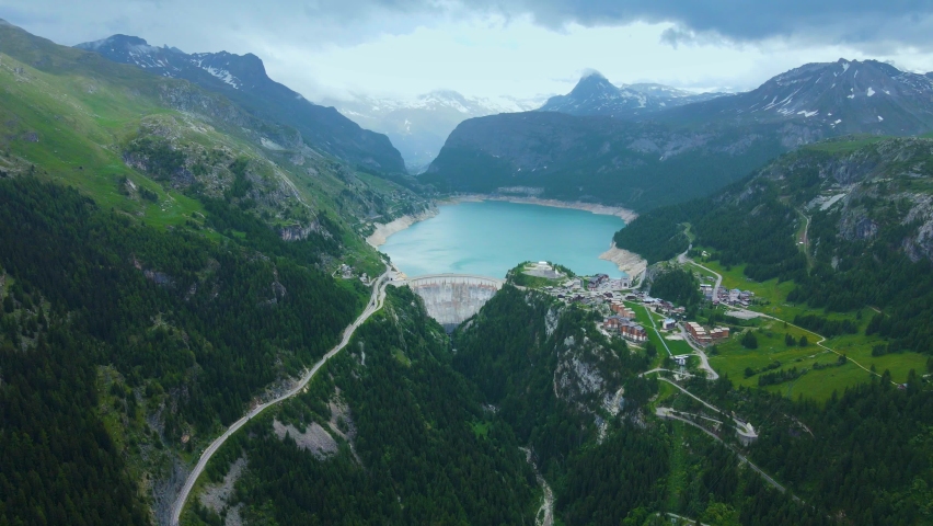 Water dam and reservoir lake aerial drone footage in French Alps mountains generating hydroelectricity. Low CO2 footprint, decarbonize, renewable energy, sustainable development. 4K 60fps video. Royalty-Free Stock Footage #1091280747