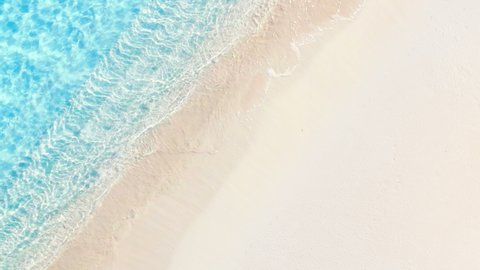 Beautiful Beach with copy space. Sunny tropical Caribbean beach and turquoise water, White Sand beach top view island vacation, hot summer day. Holiday summer beach background in 4K. Soft blue ocean.