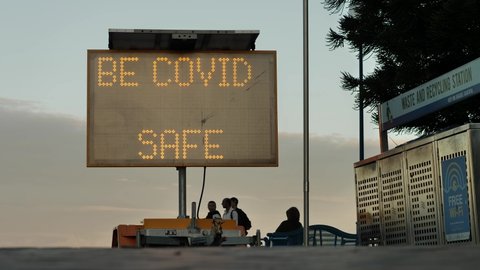 SYDNEY, NSW, AUSTRALIA. APRIL 30 2022. Be Covid Safe sign at Coogee beach Sydney, slow motion.