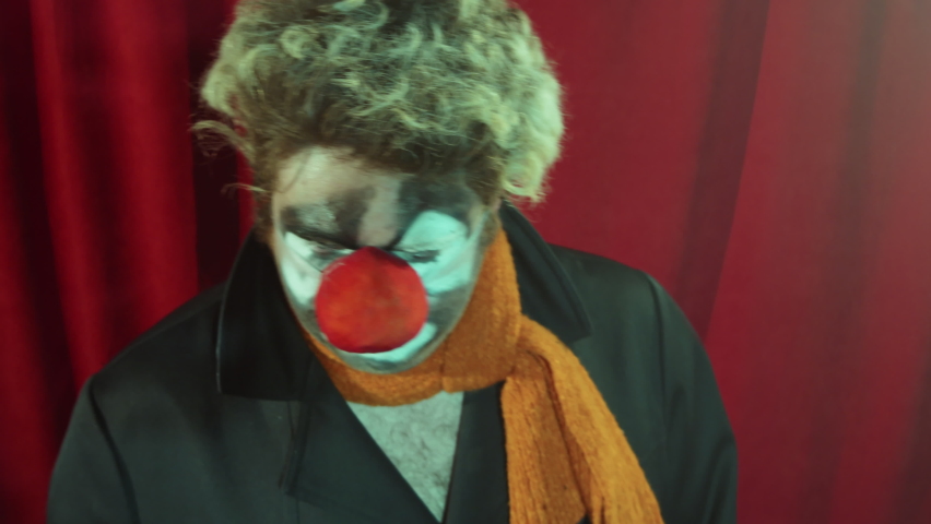 Clown with makeup and red nose singing in microphone on stage and looking at camera Royalty-Free Stock Footage #1091283693