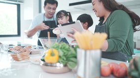 family person using digital tablet to learning to cooking a food in kitchen, child daughter with mother and father lifestyle at home together, fresh vegetable salad and meal for learn to making menu - Powered by Shutterstock - Get 15% off with code: PIKWIZARD15