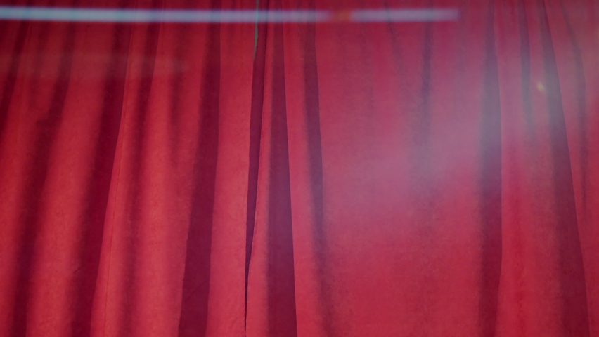 Clown walking on stage through red curtains and performing comedy with empty wooden frame Royalty-Free Stock Footage #1091284423