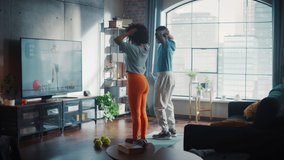 Athletic Black Couple Training Together, Jumping Following Online Video Exercise from Professional Trainer on TV in Bright Sunny Room at Home. Beautiful Boyfriend and Girlfriend Workout Together