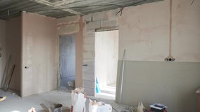 Video of apartment room with two doorways before and after restoration. Comparison of new renovated room with wooden doors and old place with construction materials.