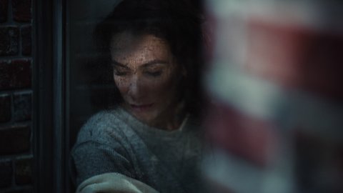 Hispanic Female Suffering from Depressio, Work Stress and Relationship Problems Looks Thoughtfully out of the Rainy Window. Portrait of a Troubled Lonely Woman. Mental Health, Domestic Abuse concept