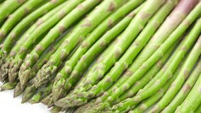 Fresh asparagus on white background, sliding shot. Healthy vegan food