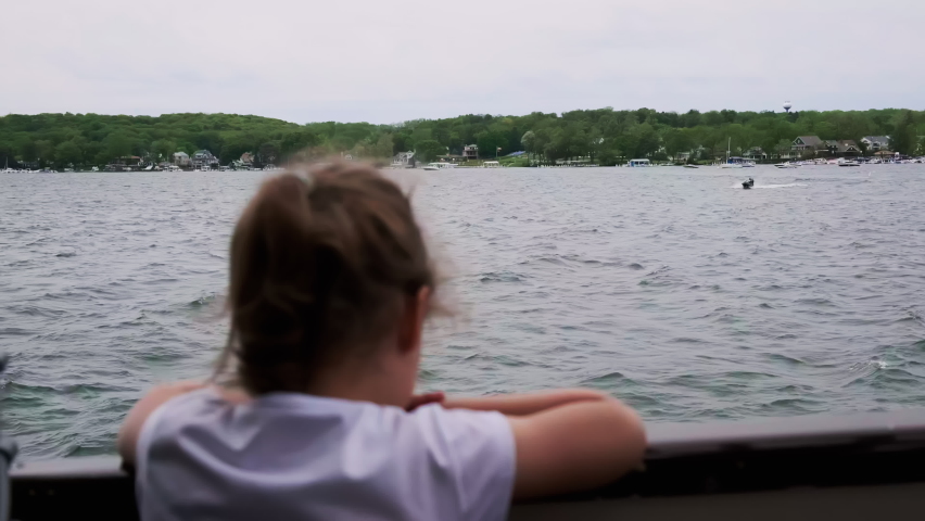 Blurred girl on board the ferry looks at the lake