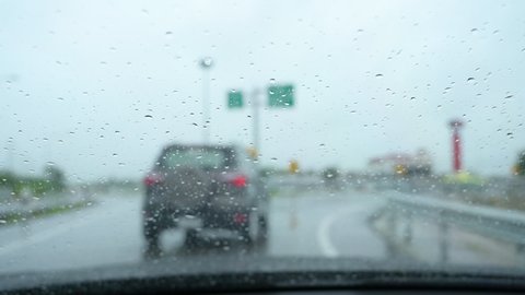 slow motion scene, drive car in rainy day, windshield wiper clean rain drop on windscreen
