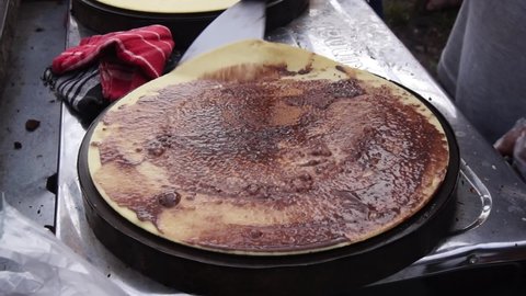 The process of making crepes is filled with spread of chocolate and cheese. Thin pancakes, blini. Sweet dessert. close-up view