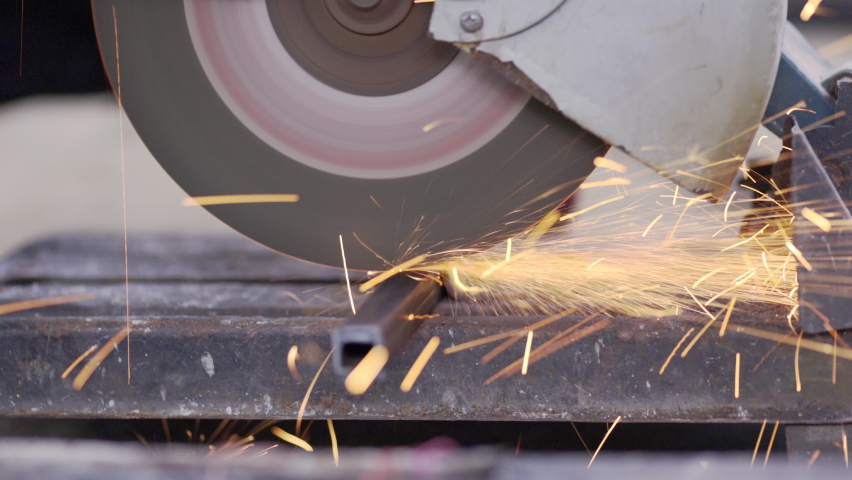 Worker using metal cutting circular saw blade in constuction site.