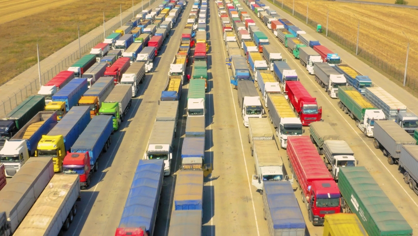 A huge queue of trucks loaded with grain crops in a blocked Ukrainian port. Humanitarian crisis due to the war. Royalty-Free Stock Footage #1091314883