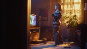 Nostalgic Retro Childhood Concept. Young Girl Dancing to Music Video on TV Channel in Her Room with Dated Interior. Excited Kid Repeat Dance Moves Dancers Perform in the Clip.