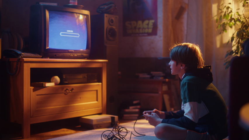 Nostalgic Childhood Concept: Young Boy Playing Old-School Arcade Space Shooter Video Game on a Retro TV Set at Home in His Room with Period-Correct Interior. Successful Kid Passes the Level and Wins. Royalty-Free Stock Footage #1091320895