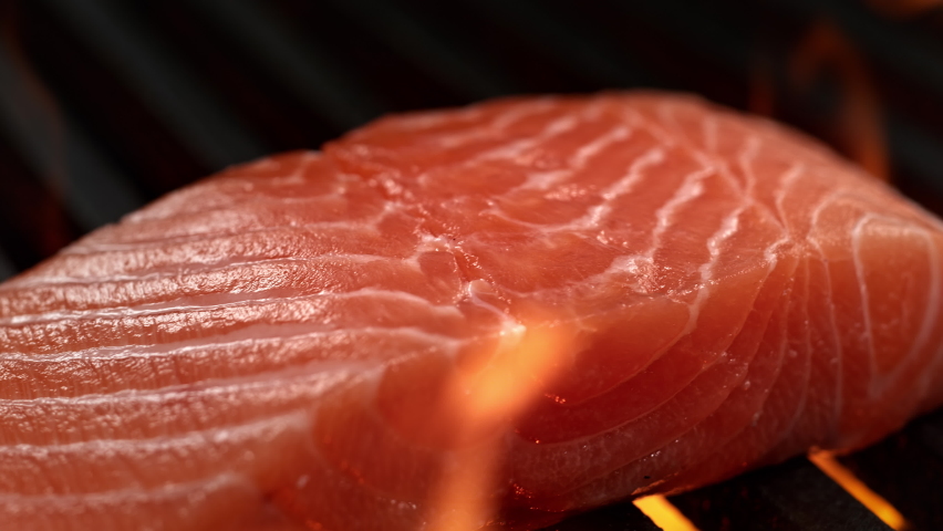 Raw Salmon Fillet on Grill Grate Flaming in Slow Motion - Macro Dolly Shot of Barbecued Fish and Fire