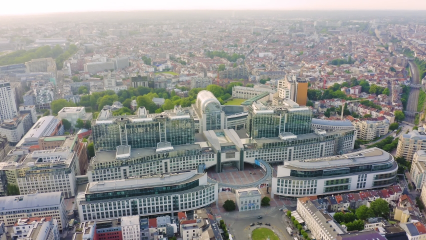 Inscription on video. Brussels, Belgium. The complex of buildings of the European Parliament. State institution. Appears from the sand, Aerial View, Point of interest