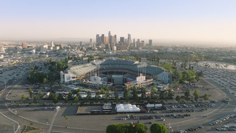 Aerial massive Dodgers Stadium in sunset light. Cityscape drone panorama 4K. Los Angeles city buildings skyline downtown at cinematic golden sunshine. Dodgers Stadium, Los Angeles June 2022