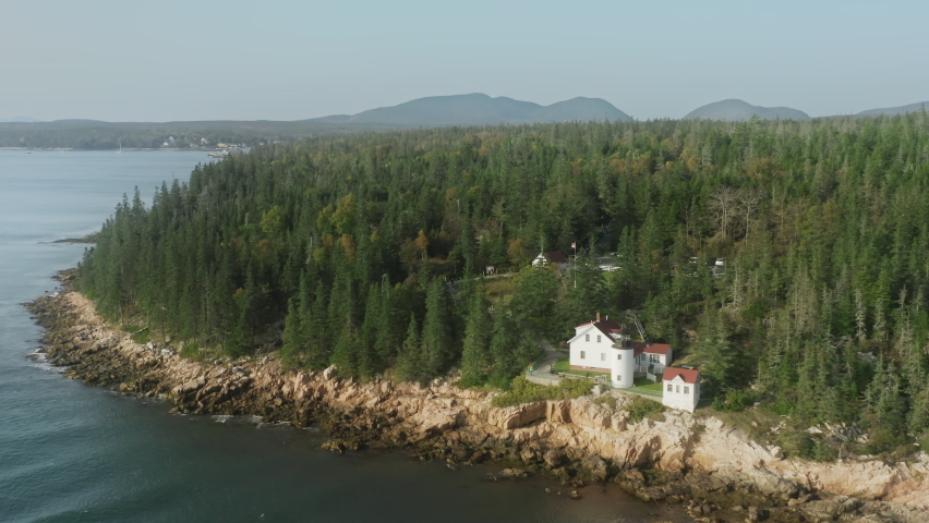 Aerial Bass Harbor Head Lighthouse landmark at Bass Harbor, Maine. Scenic rugged coastline of Mount Desert Island in Acadia National Park. Travelers exploring dramatic Acadia rocky coastline, USA trip
