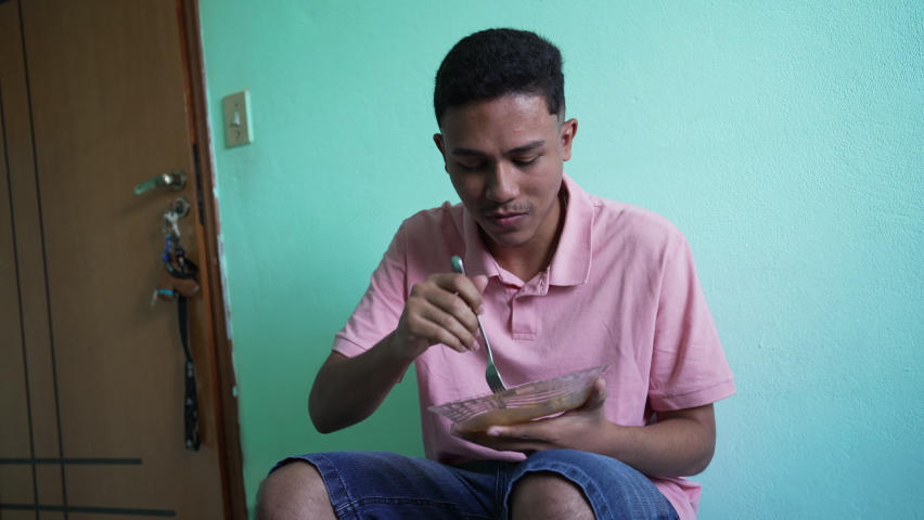 Brazilian man eating lunch at home. One latin hispanic person eats food