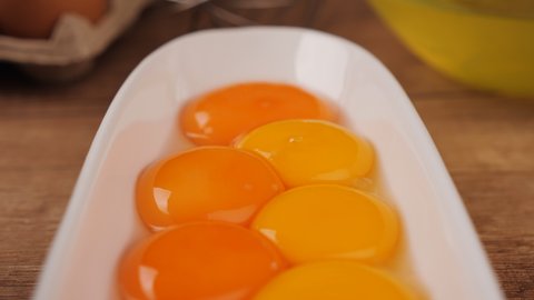 Many eggs yolks separated from white, close up, camera slide. Yolks for preparing various dishes. Yolk for cooking