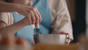 mother and daughter are cooking in home, closeup of hands of woman and little girl mixing dough by whisk - Powered by Shutterstock - Get 15% off with code: PIKWIZARD15