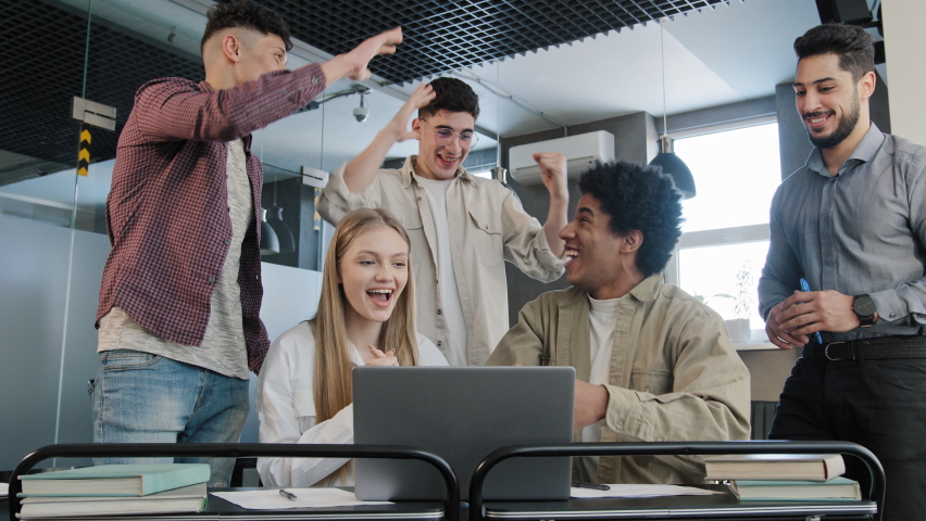Young corporate employees sitting in office looking at laptop screen reading good news excited happy team diverse people celebrating victory win command success excellent result professional teamwork Royalty-Free Stock Footage #1091342929
