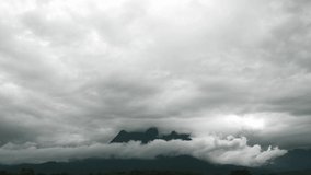Time lapse, fast speed overcast cloudy moving over sky covered and hidden huge mountain after foggy cloud