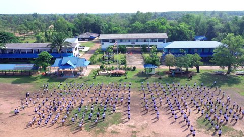 NAKHON PHANOM,THAILAND-MAY 18,2022:Teachers and students line up to respect the national anthem and perform activities in front of the flagpole in Thailand.