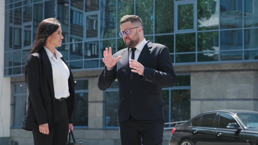Two business people man and woman shaking hands outdoors near business center.People discuss the details of the work.Meeting of business partners. Royalty-Free Stock Footage #1091360025