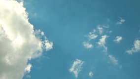 White clouds fly across a bright blue sky, Cloud time lapse nature background.
