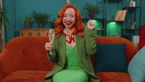 Joyful redhead woman hold glass of champagne cheering and drinking, celebrate success win, career grow up, lucky situation at home in living room. Ginger girl celebrating rent or purchase of new house - Powered by Shutterstock - Get 15% off with code: PIKWIZARD15