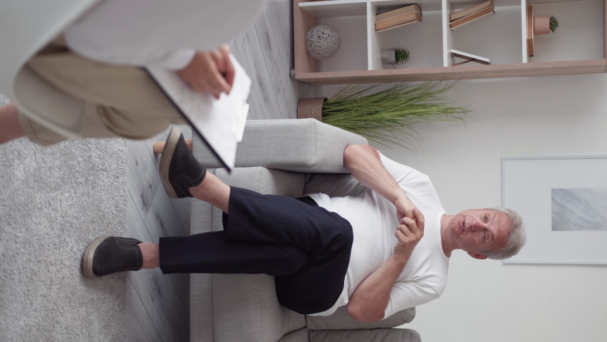 Psychology counseling. Mental support. Professional therapy. Anxious middle-aged man on couch sharing problem with female psychotherapist in modern interior vertical. | Shutterstock HD Video #1091363755