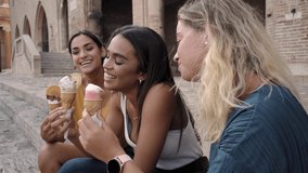 Three joyful young girl friends on a promenade smiling happily as they enjoy takeaway ice cream cones on summer vacation - Powered by Shutterstock - Get 15% off with code: PIKWIZARD15