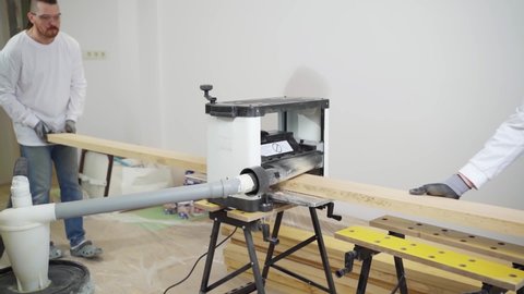carpenters working with wood on the planer, planing machine, thickening machine. services of a professional carpenter. manufacture of furniture from natural wood to order