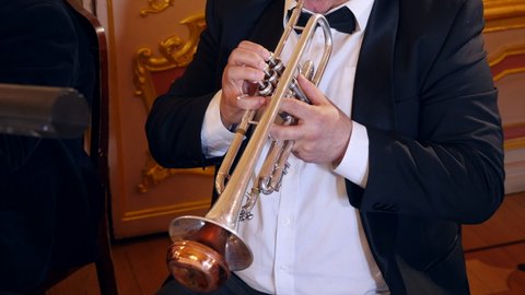 Closeup of trumpeter musician fingering trumpet in symphony orchestra