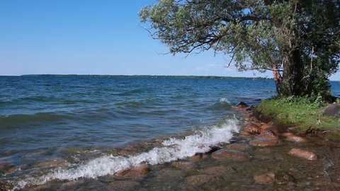 Clear water waves from Lake Simcoe washing pebble beach in Sibbald Point Provincial Park, Ontario, Canada