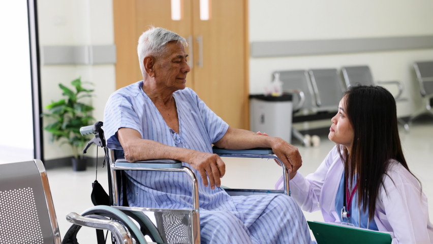 Asian elder male patient sitting on wheelchair. Woman doctor talk with senior patient at ceception medical hospital. | Shutterstock HD Video #1091383823