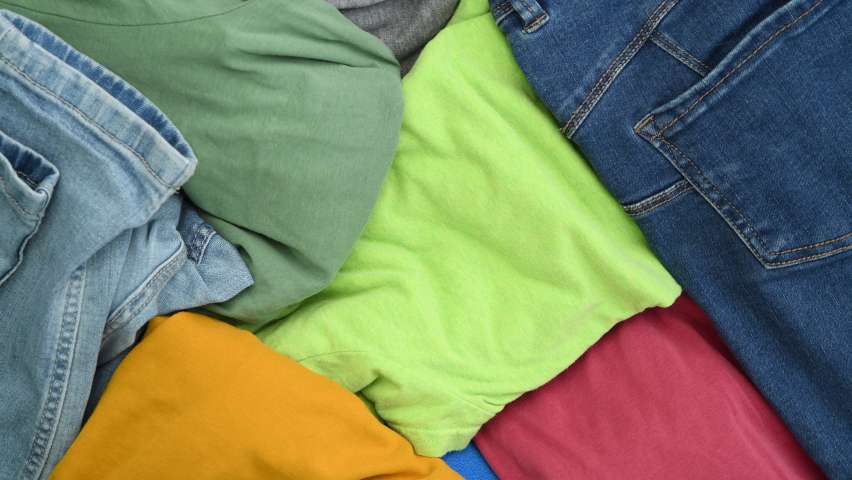 Heap of various colourful clothes prepared for laundry or recycling, top view, rotating | Shutterstock HD Video #1091385261