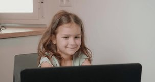 Cute girl shows drawing in notepad to mom via video call