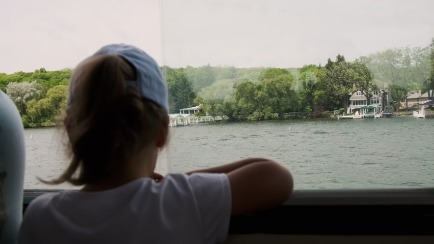 Blurred girl on board the ferry looks at the lake. Close up
