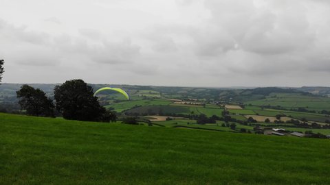 Forward shot following a Paraglider soring into the sky over the English Countryside