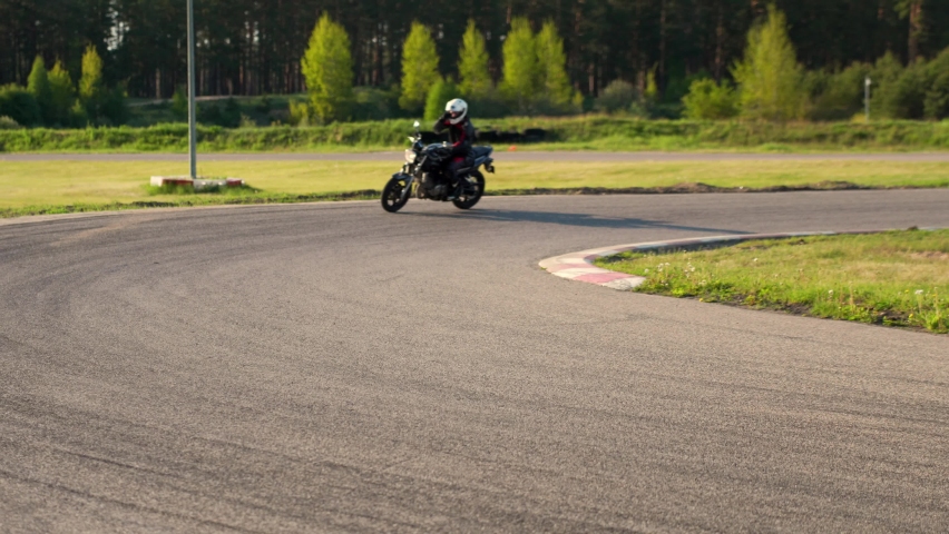 Cornering casually on a roadster motorcycle wearing protective gear