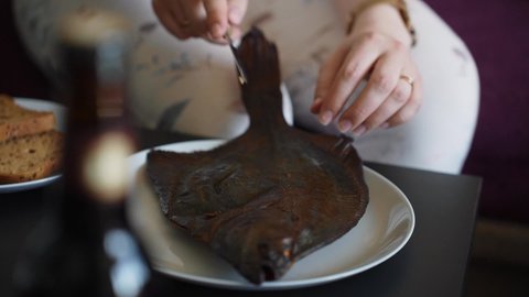 Over burnt smoked flounder fish slicing for serving